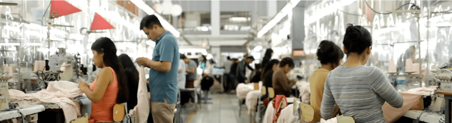 Multiple people working together to sew clothing.